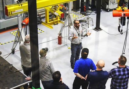 Image of Man standing in front of a large group of people lecturing