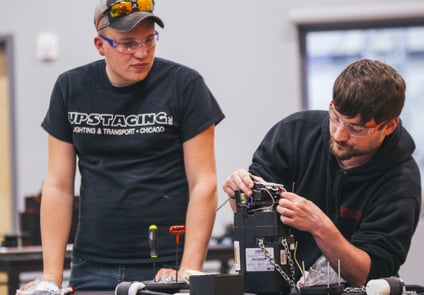 Image of two people working together for chain and wire rope hoist maintenance and repairs