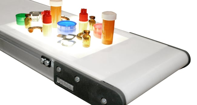 Image of Conveyor with pharmaceutical products and other miscellaneous on top