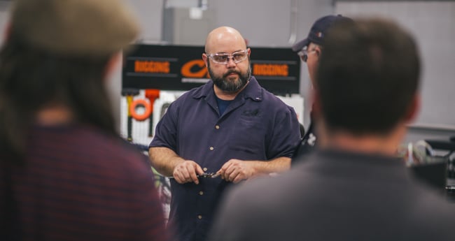 Image of man wearing safety glasses teaching a group of people