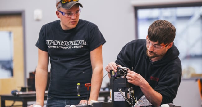 Image of two people working together for chain and wire rope hoist maintenance and repairs