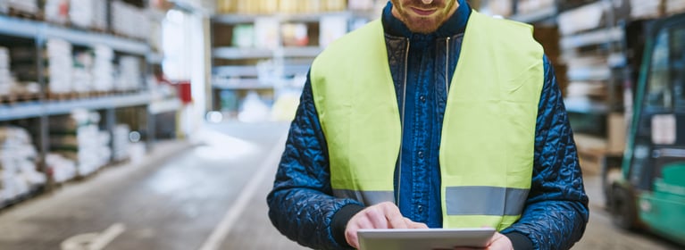Image of man in safety vest looking at iPad